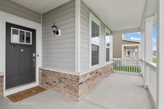 view of exterior entry featuring covered porch