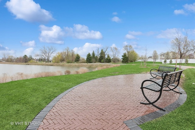 view of home's community featuring a lawn and a water view