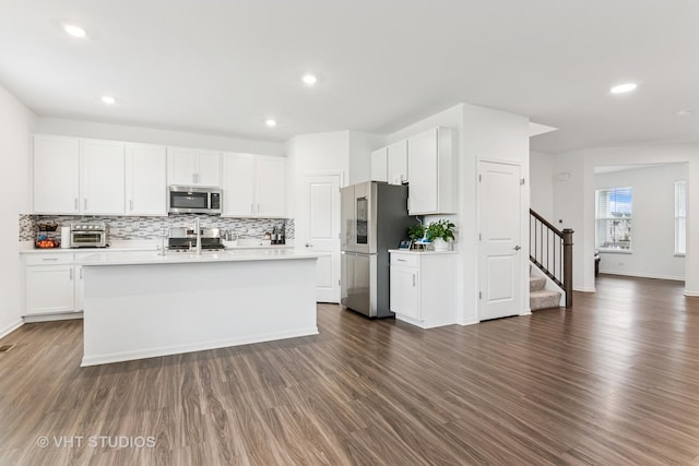 kitchen featuring light countertops, white cabinetry, tasteful backsplash, and stainless steel appliances