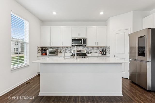 kitchen featuring decorative backsplash, dark wood-style floors, light countertops, white cabinetry, and stainless steel appliances