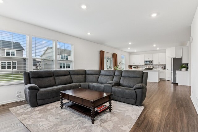 living area featuring baseboards, visible vents, recessed lighting, and dark wood-type flooring