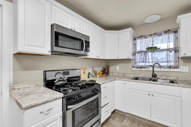 302 Flora Dr, Champaign, IL 61821 - kitchen featuring appliances with stainless steel finishes, a sink, white cabinets, and light countertops