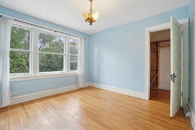 3945 W Dakin St, Chicago, IL 60618 - spare room featuring light wood-style flooring and a chandelier