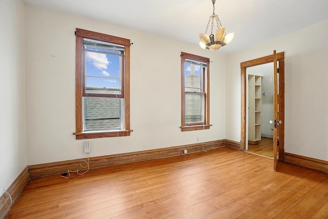 3945 W Dakin St, Chicago, IL 60618 - empty room with light wood-type flooring and a chandelier