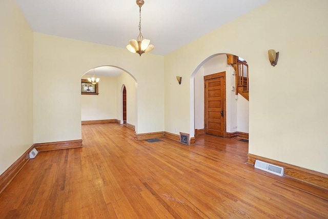 3945 W Dakin St, Chicago, IL 60618 - empty room with arched walkways, a chandelier, and light wood finished floors