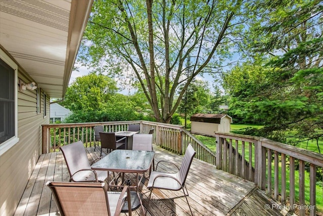 537 71st St, Darien, IL 60561 - wooden deck featuring outdoor dining space, a storage unit, and view of wooded area