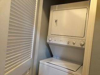 washroom featuring stacked washer and dryer and laundry area