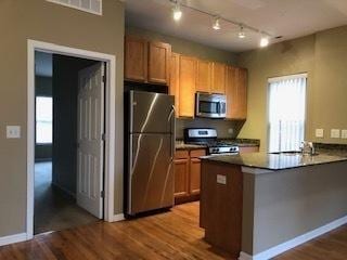 343 E 25th Pl Unit 18C, Chicago, IL 60616 - kitchen with appliances with stainless steel finishes, dark wood-style flooring, brown cabinetry, and a peninsula