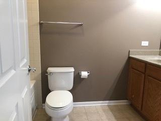 343 E 25th Pl Unit 18C, Chicago, IL 60616 - full bathroom featuring toilet, vanity, baseboards, and shower / bath combination