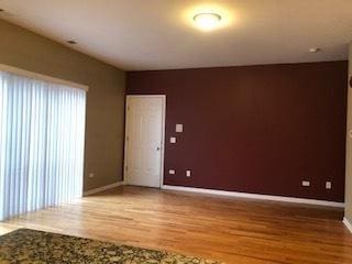 unfurnished room with baseboards and light wood finished floors