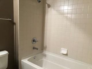 bathroom with toilet and washtub / shower combination