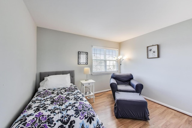 bedroom with baseboards and wood finished floors