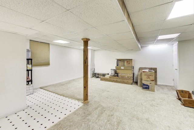 finished below grade area with baseboards, carpet, and a drop ceiling