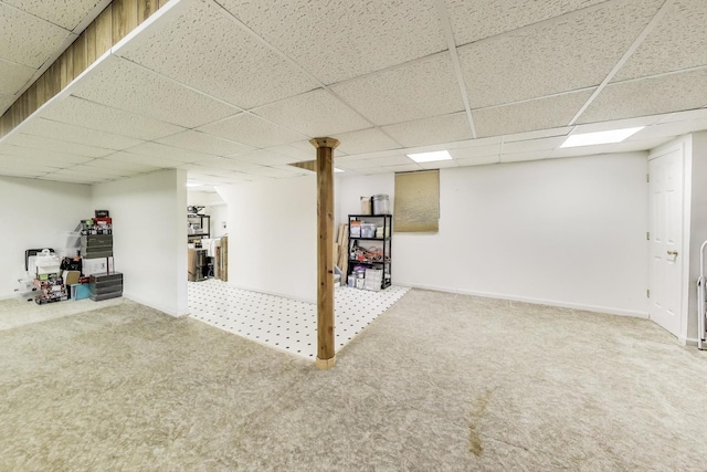 finished below grade area with baseboards, carpet, and a paneled ceiling