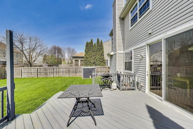 wooden terrace featuring a fenced backyard and a lawn