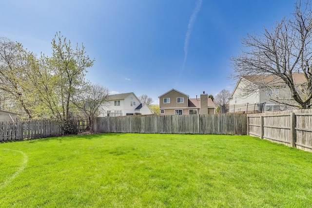 view of yard featuring a fenced backyard and a residential view