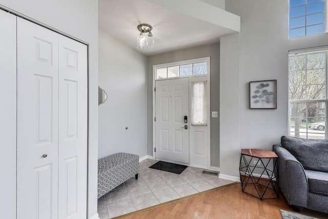 entrance foyer with baseboards, light tile patterned flooring, and visible vents