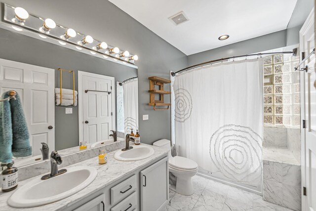 5016 N Sheridan Rd Unit 1, Chicago, IL 60640 - full bath featuring double vanity, visible vents, marble finish floor, and a sink