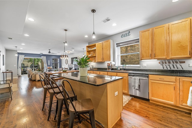 5016 N Sheridan Rd Unit 1, Chicago, IL 60640 - kitchen featuring wood finished floors, open floor plan, a kitchen bar, stainless steel dishwasher, and hanging light fixtures