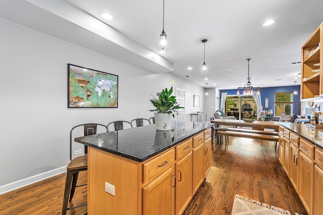 5016 N Sheridan Rd Unit 1, Chicago, IL 60640 - kitchen featuring a center island, dark stone counters, a kitchen breakfast bar, open floor plan, and dark wood finished floors