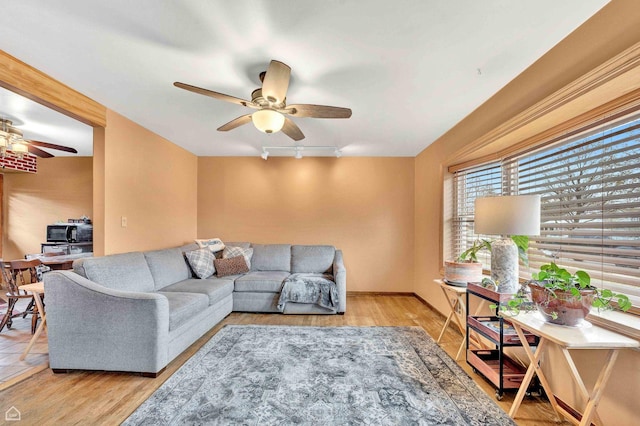 living area with wood finished floors and ceiling fan
