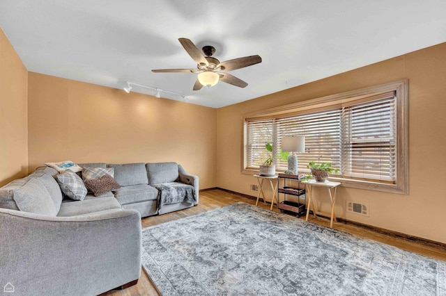 living room with visible vents, wood finished floors, a ceiling fan, and rail lighting