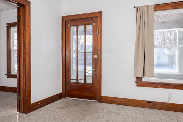 foyer featuring carpet, baseboards, and plenty of natural light