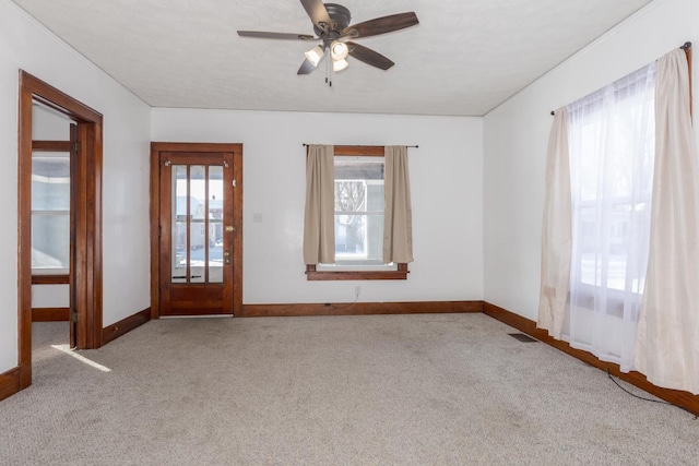 unfurnished room with visible vents, baseboards, carpet flooring, and ceiling fan
