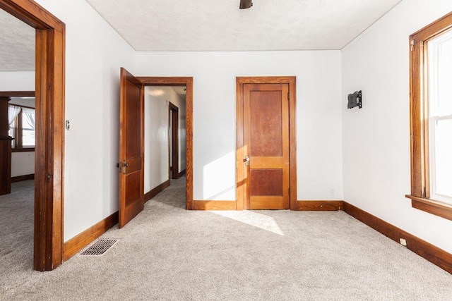 carpeted empty room featuring visible vents and baseboards