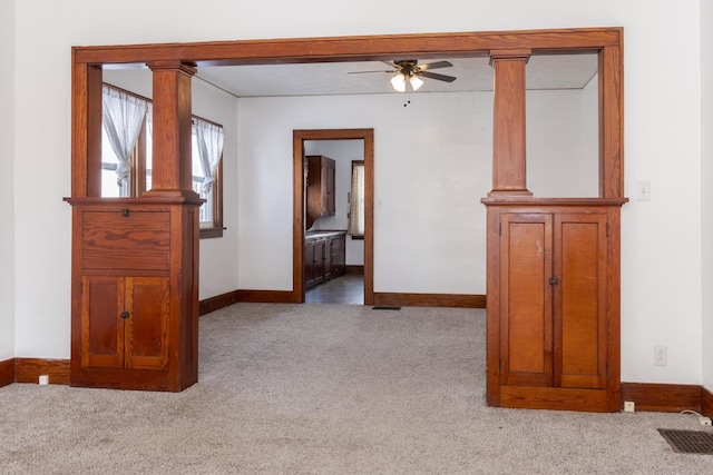 spare room with carpet, visible vents, baseboards, and ceiling fan