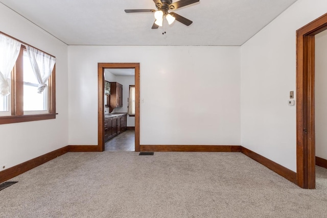 empty room featuring visible vents, baseboards, carpet flooring, and ceiling fan
