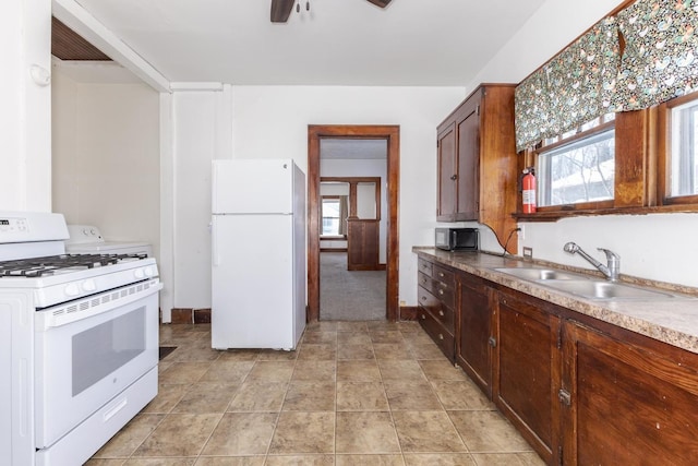 kitchen with baseboards, a ceiling fan, a sink, and white appliances