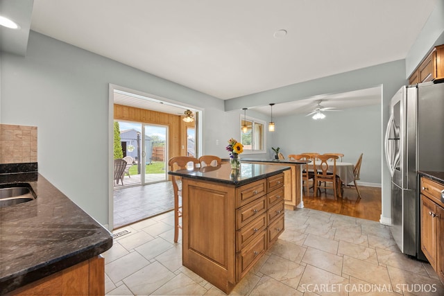 2288 Westminster St, Wheaton, IL 60189 - kitchen with freestanding refrigerator, a breakfast bar, brown cabinetry, and plenty of natural light