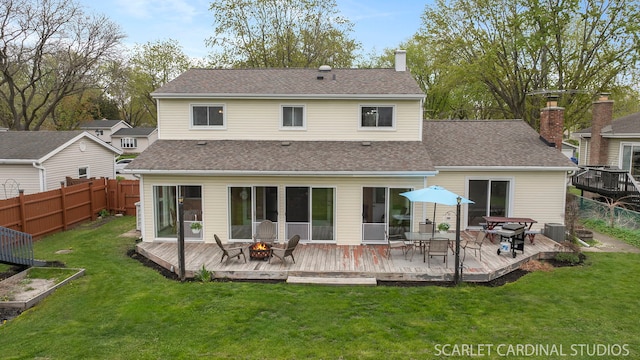 2288 Westminster St, Wheaton, IL 60189 - back of house featuring a wooden deck, a fenced backyard, a chimney, a lawn, and a fire pit