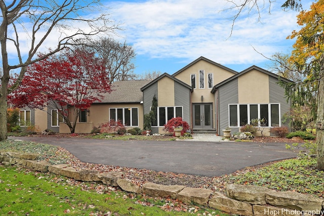 back of property with french doors and stucco siding