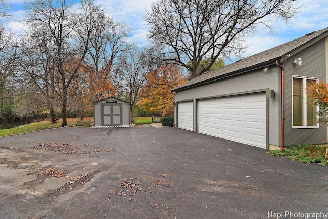 garage featuring a storage unit and driveway