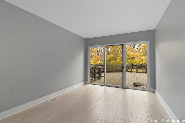 unfurnished room with visible vents and baseboards