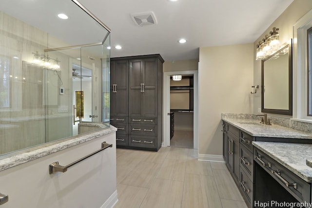 bathroom with vanity, visible vents, baseboards, and a stall shower