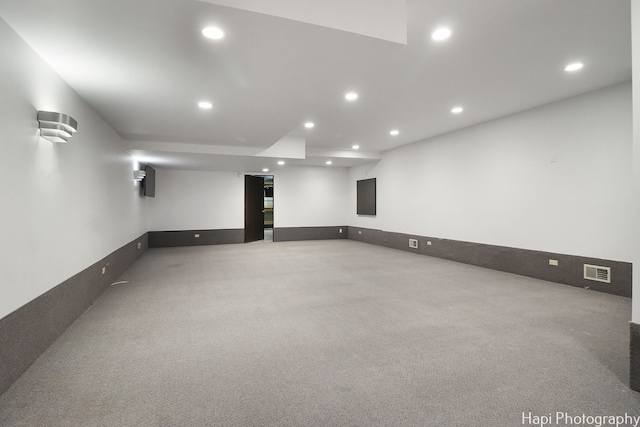 finished below grade area featuring light carpet, visible vents, and recessed lighting