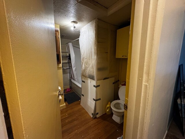 full bathroom with shower / bath combination with curtain, toilet, and wood finished floors