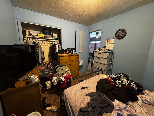 bedroom with a textured ceiling, carpet floors, and a closet