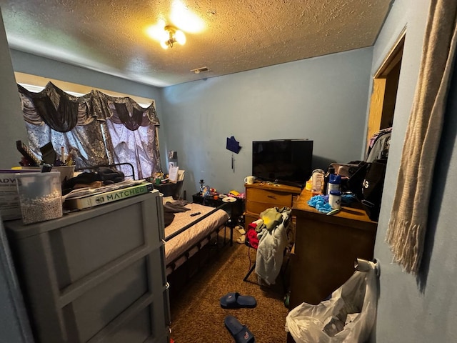 bedroom featuring carpet floors, visible vents, and a textured ceiling