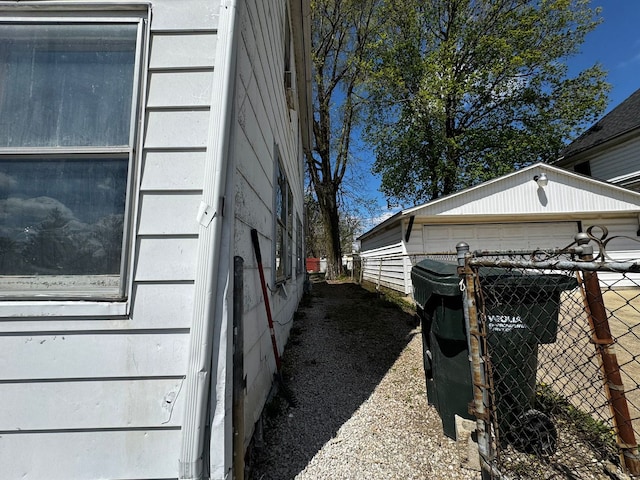 view of side of property with an outdoor structure and fence