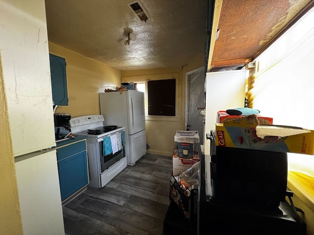 kitchen with dark wood finished floors, visible vents, blue cabinets, and white appliances