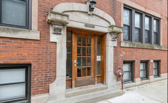 doorway to property featuring brick siding