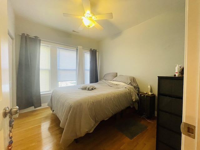 bedroom with baseboards, a ceiling fan, and wood finished floors