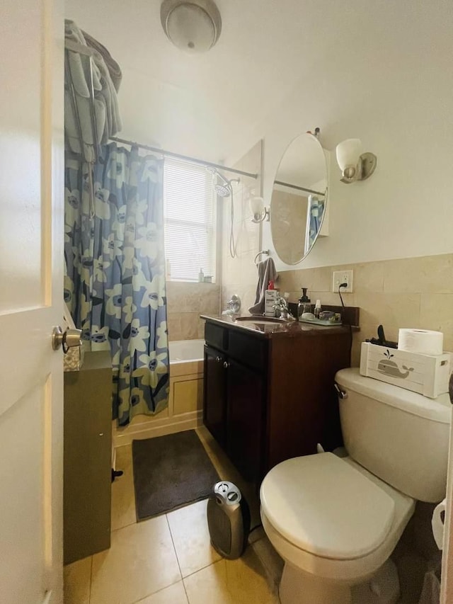 bathroom with tile patterned floors, vanity, tile walls, shower / tub combo, and toilet