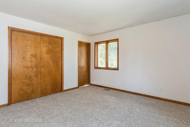 unfurnished bedroom with baseboards, visible vents, and light colored carpet