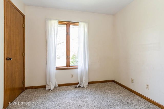 unfurnished room featuring baseboards and light carpet