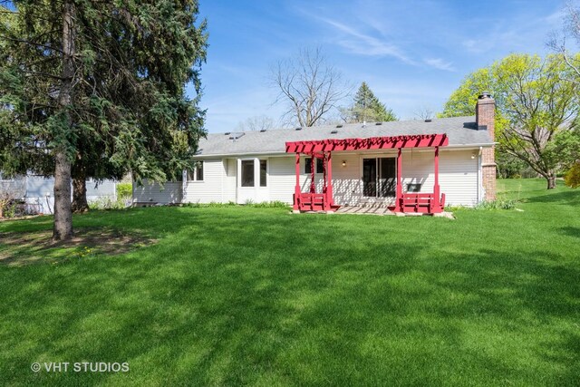 back of property featuring a chimney, a yard, and a patio area